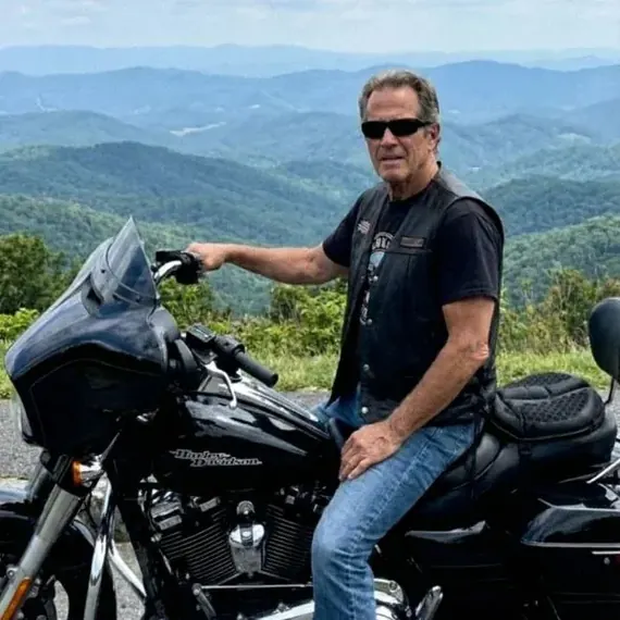 Gérard L. sur sa Harley-Davidson, en surplomb des montagnes