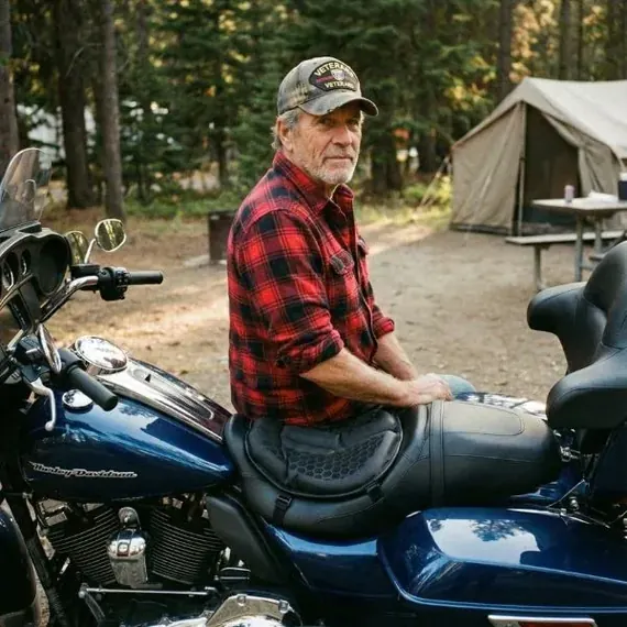 Robert P. assis sur sa Harley équipée de SelleZen, au campement